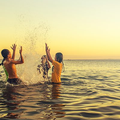 Live Well - Kids playing in the water at sunset